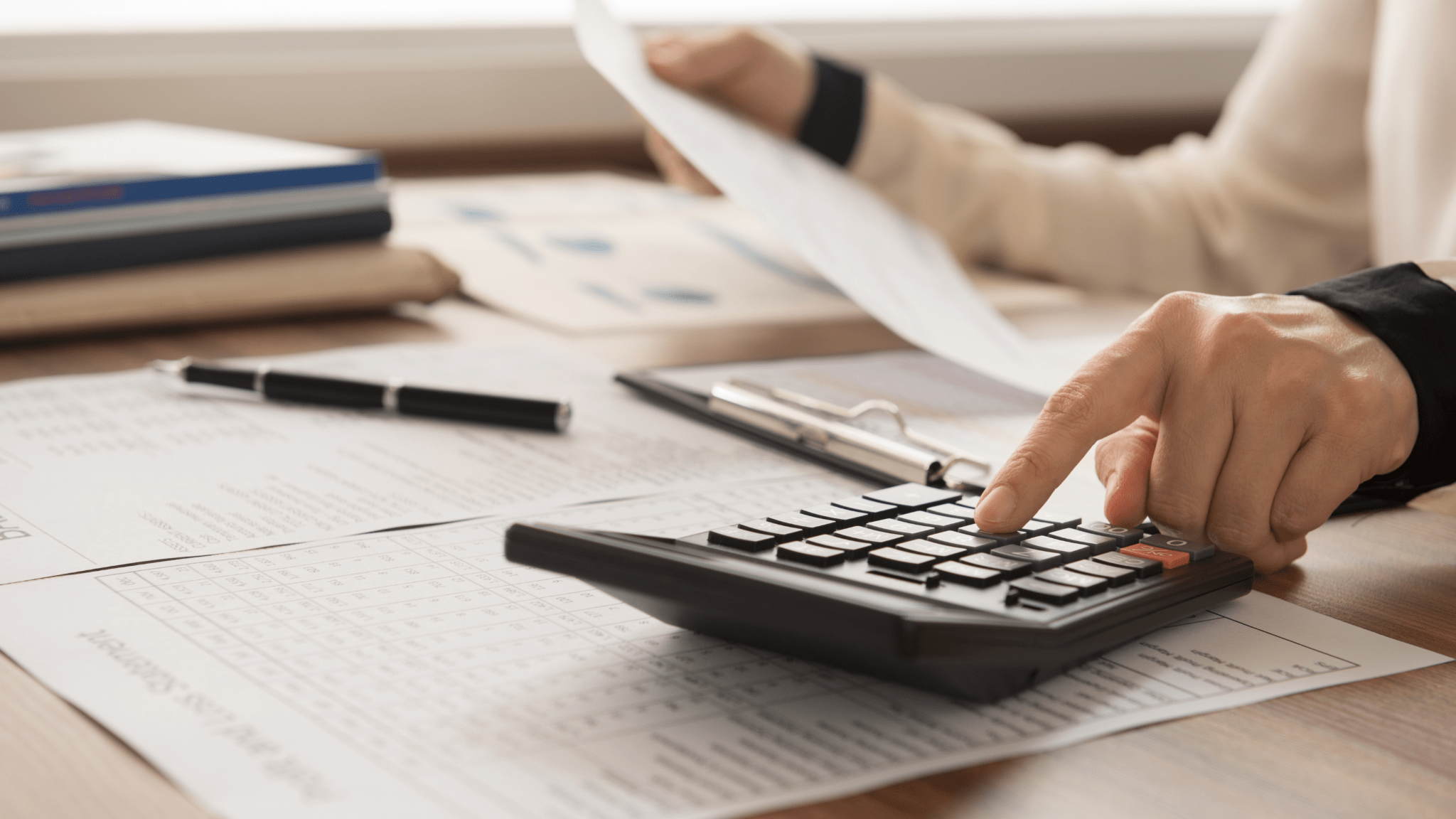 Finance Woman typing on a calculator on a desk