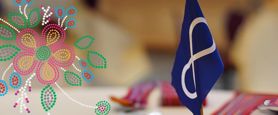 Miniature Indigenous infinity loop flag with a red Metis sash in the foreground and traditional beadwork design overlay