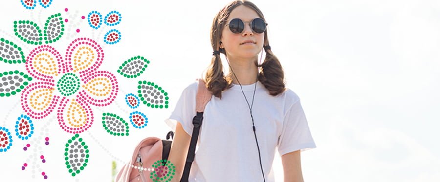 Young woman listening to headphones while carrying a backpack next to a Metis style bead work design